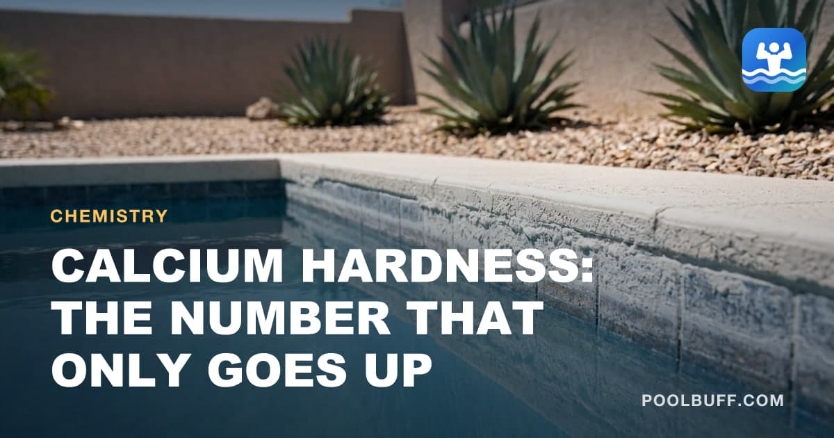 A hard white calcium crust banded along pool waterline tile, the deposit rough and uneven where it meets clear water