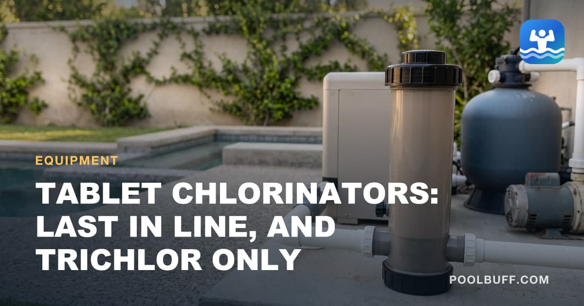 A tall taupe tablet chlorinator with a black cap in the white PVC return line on a concrete pad, a gray check valve ahead of it, and a heater and sand filter behind