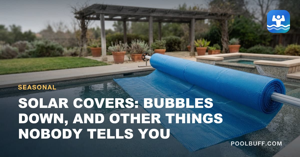 A blue bubble solar cover being rolled across a pool